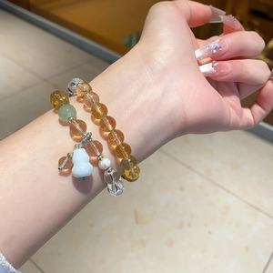Detail of luxury crystal beaded bracelet set with white chalcedony and gourd charm on wrist