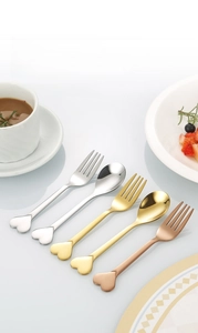 Close-up of heart-shaped handle dessert spoon and fork set in polished stainless steel