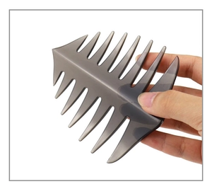 Detailed view of dark grey fishbone styling comb held in hand for size comparison