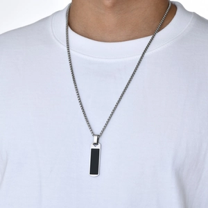 Close-up of a stylish men's black rectangular pendant with a polished silver chain