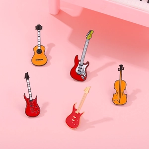Set of five colorful musical instrument enamel pins featuring guitars and cello on pink base