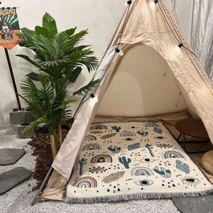 Detail of bohemian woven camping blanket with colorful totems and grey fringe tassels