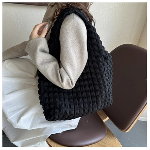 Vue détaillée de la texture gaufrée noire d'un sac cabas souple et léger