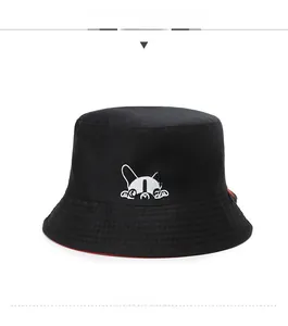 Détail du chapeau bob réversible noir avec broderie de chien blanc et doublure rouge vive