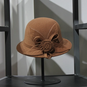 Detailed view of dark brown wool dome hat with hand-woven floral and leaf decor