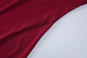 Macro shot of burgundy dress fabric showing high-quality knit texture and smooth stitching