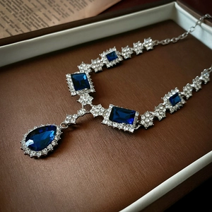 Detail of luxury necklace with blue teardrop crystals and sparkling rhinestones in a gift box