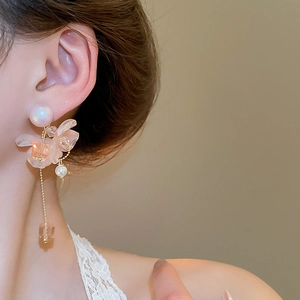 Dettaglio degli eleganti orecchini a nappa con fiori e perle per un look grazioso