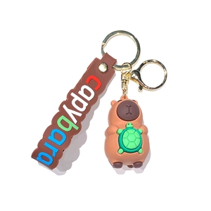Cute Capybara keychain with green turtle backpack and brown wrist strap on white background
