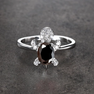 Macro detail of silver turtle ring with black oval stone and white cubic zirconia