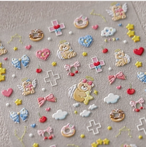 Macro shot of 3D embossed nail stickers featuring cute angels, bears and pastel hearts