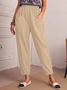 Detail of light khaki cotton linen pants featuring elastic waist and functional side pockets