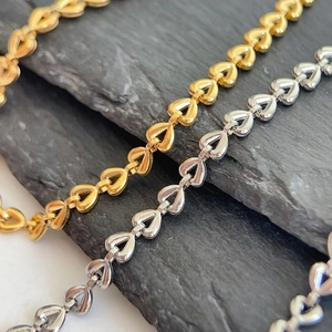 18K gold-plated heart-shaped link bracelets in gold and silver finish on dark stone
