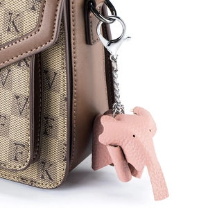 Pink leather elephant keychain charm on a brown textured leather and fabric handbag