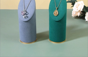 Detail of luxury necklace display stands with butterfly pendants on velvet cylinders