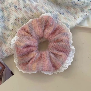 Detailed close-up of pink and purple tie-dye knit scrunchie with white lace trim