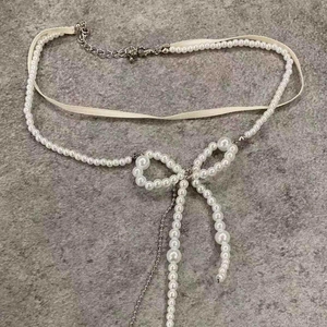 Elegant double-layered pearl necklace with bow pendant and cream ribbon detail