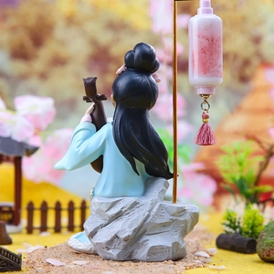 Macro shot of ancient style lady figurine with pipa and pink lantern on a rocky base