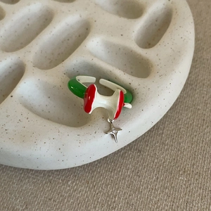 Close-up of enamel apple core open ring with a tiny silver star pendant and zircon
