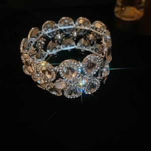 Macro detail of silver elastic bracelet featuring pear-cut crystal inlay on black surface