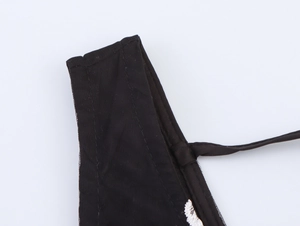 Détail de la couture des bretelles et texture d'une robe longue noire à fleurs 3D