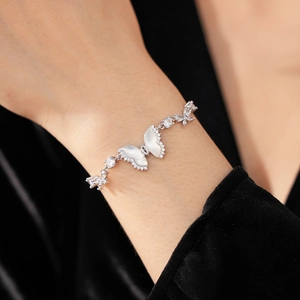 Detail of silver butterfly bracelet featuring white mother of pearl and marquise zircons