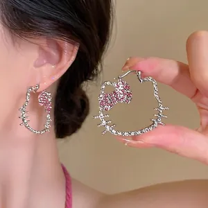 Close-up of Hello Kitty shaped earrings with pink and white crystal rhinestones