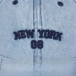 Close-up of New York 08 3D embroidery on light blue washed denim baseball cap texture