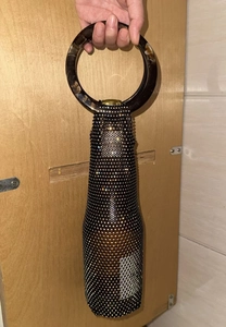 Close-up of black rhinestone wine bottle carrier bag with tortoise resin round handle
