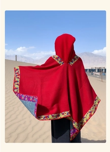 Rear view of red hooded poncho with floral borders, perfect for outdoor desert travel
