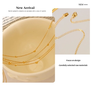 Detail showing heart charms on 18K gold-plated titanium necklace over a vintage background