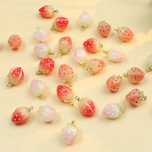 DIY strawberry charms in red and pink gradients with gold loops for handmade jewelry making