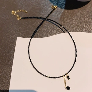 Elegant black beaded necklace with golden rectangle and round charms, stylish choker