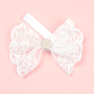 Detail showing white lace bow headband with faux pearls and rhinestones for baby girls