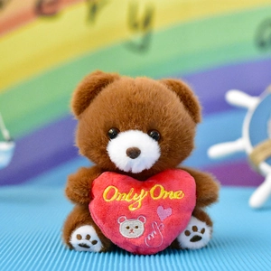 Close-up detail of cute brown plush teddy bear holding a red heart with Only One text.