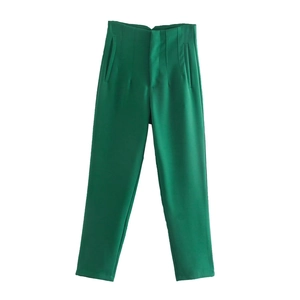 Dettaglio dei pantaloni verdi a vita alta con pieghe eleganti e tasche laterali