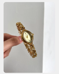 Detailed view of vintage gold camellia bracelet watch with oval dial and crystals