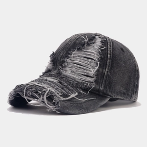 Close-up of distressed denim baseball cap with frayed edges and vintage washed finish