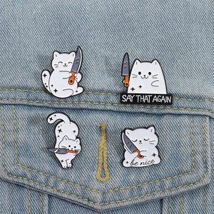 Set of 4 creative cartoon white cat enamel pins with daggers on blue denim background