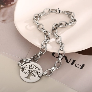 Detail of silver stainless steel Tree of Life pendant with chunky link chain on a pink plate
