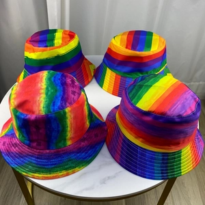 Top view of four reversible rainbow patchwork bucket hats on a marble table surface