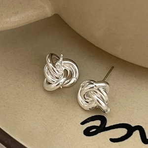 Orecchini a lobo a nodo in argento sterling 925 su vassoio di ceramica beige opaco