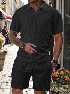 Close-up of black knit fabric texture on men's striped polo and drawstring shorts set