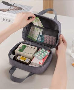 Detail view of the multi-layer interior and mesh pocket of the gray travel first aid kit