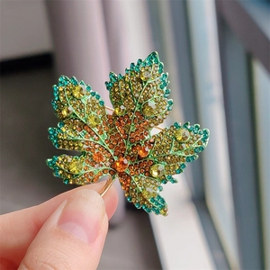 Close-up detail of luxury maple leaf brooch with vibrant gradient crystal rhinestones