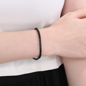 Close-up of minimalist black titanium steel fish scale link bracelet worn on a wrist