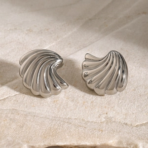 Elegant silver 18k gold stainless steel seashell stud earrings on stone background