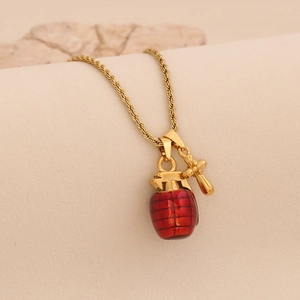 Macro shot of 3D red grenade pendant with gold accents and twisted chain necklace detail