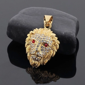 Macro detail of gold-plated lion head pendant with sparkling rhinestones on black stone