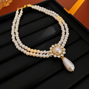 Detail of double-layer pearl necklace featuring a floral rhinestone pendant and water drop pearl